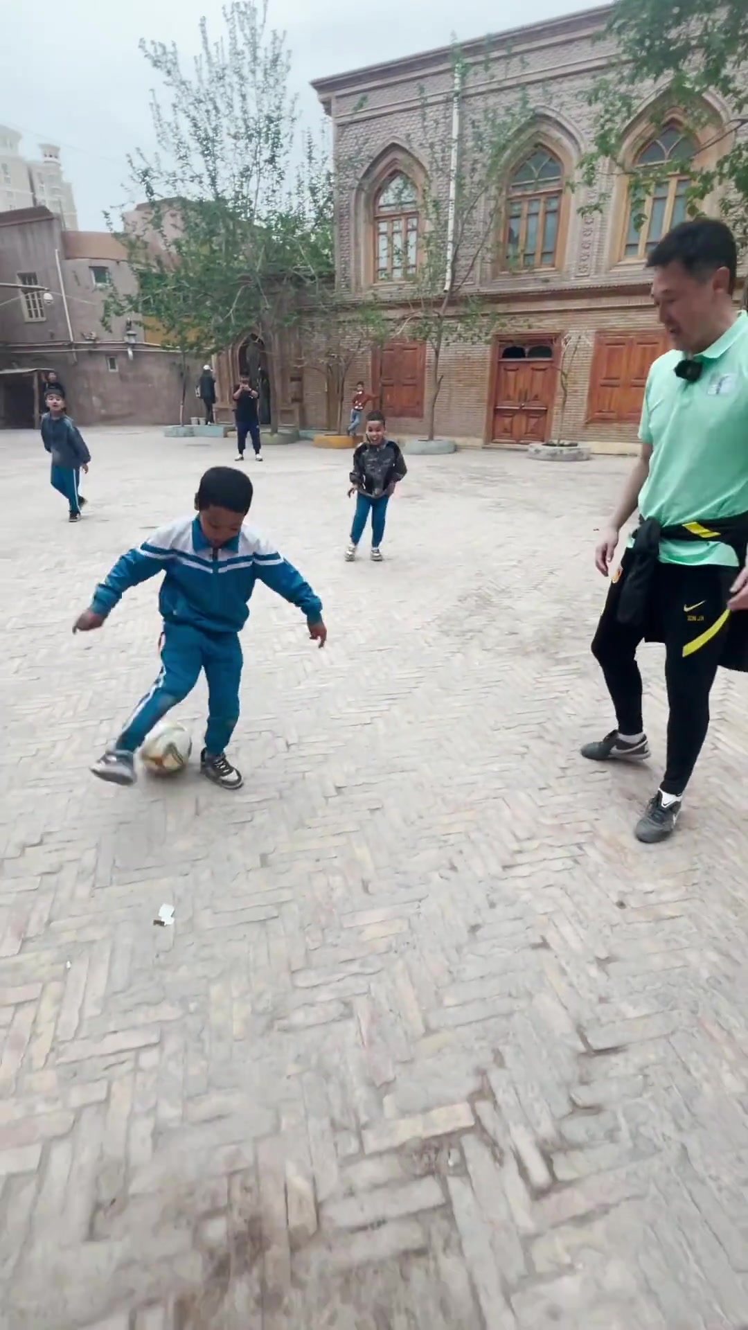 扎根青训孙继海和新疆小朋友在街头踢球
